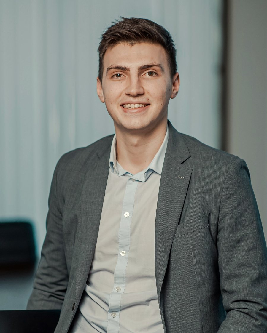 Rohan Desai, smiling, in a gray blazer in an office meeting room