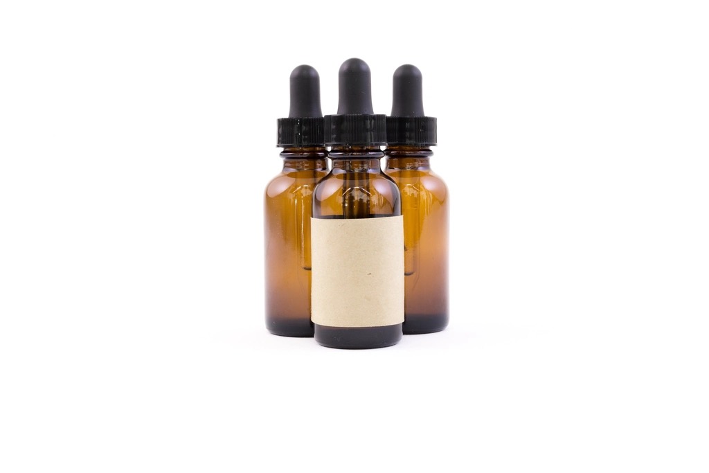 Three amber glass dropper bottles with blank paper labels