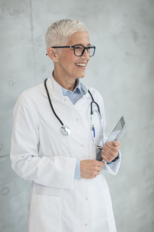 Dr. Ellen Marsh in a white coat, smiling, holding a tablet.