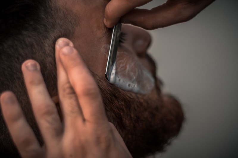 Tasha lining up a full beard with a straight razor