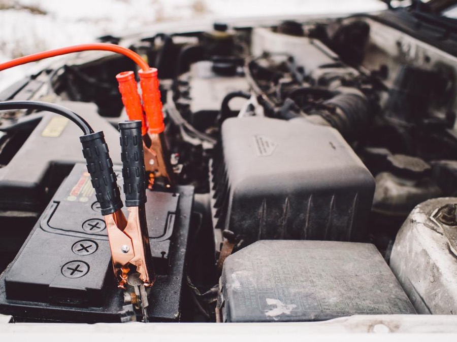 Test leads clamped to a car battery under the hood