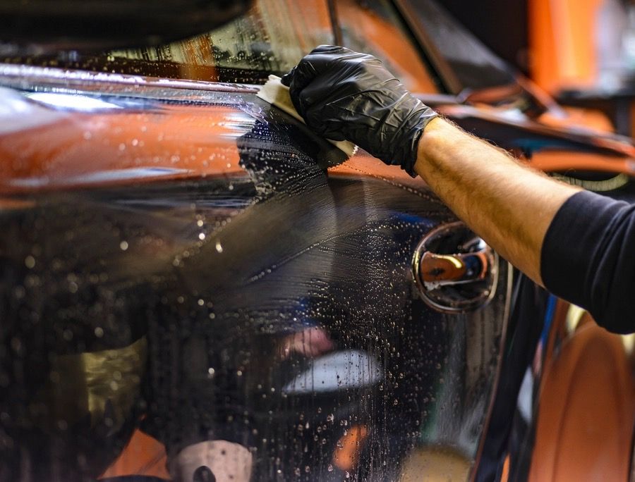 Window film being squeegeed onto a car's side glass