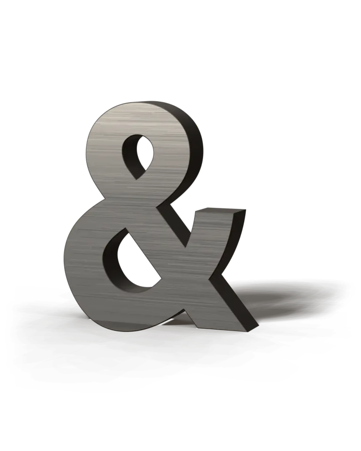 A brushed aluminum ampersand channel letter with black returns, standing on the floor.
