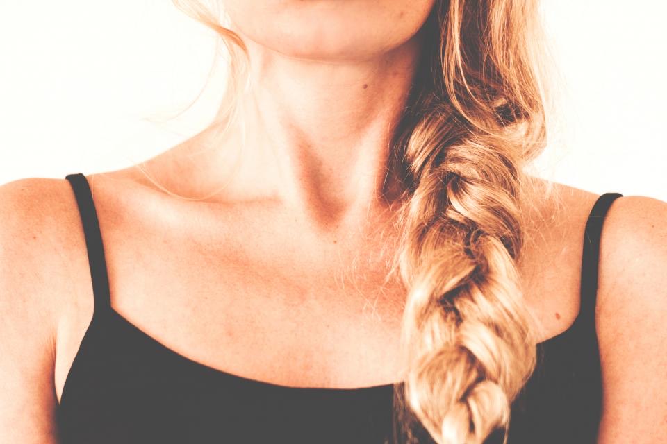 Loose side braid in golden blonde over a black top