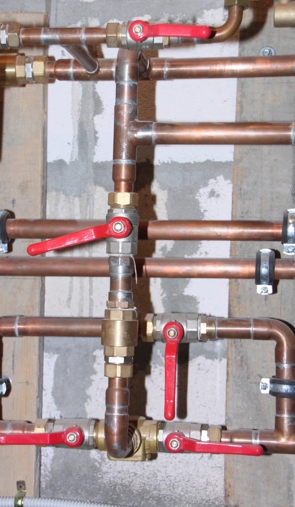 New copper heating pipes with red shutoff valves on each zone